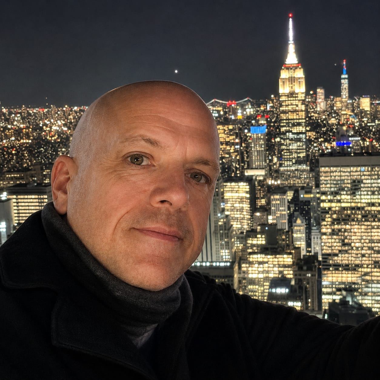 Justin Campbell, independent travel advisor, with a city skyline behind him