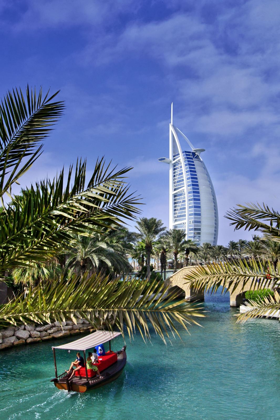 The Burj Al Arab in Dubai framed by palm leaves at golden hour